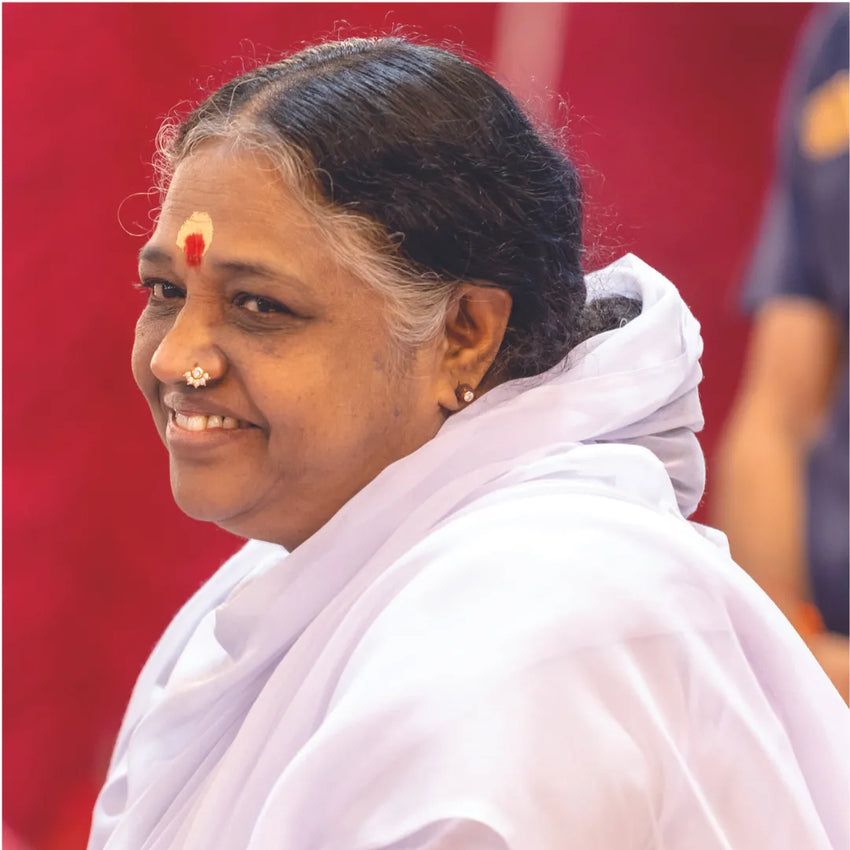 Sri Mata Amritanandamayi Devi (Amma) smiling warmly in her traditional white attire. The image reflects her compassionate nature and leadership in humanitarian and spiritual efforts.