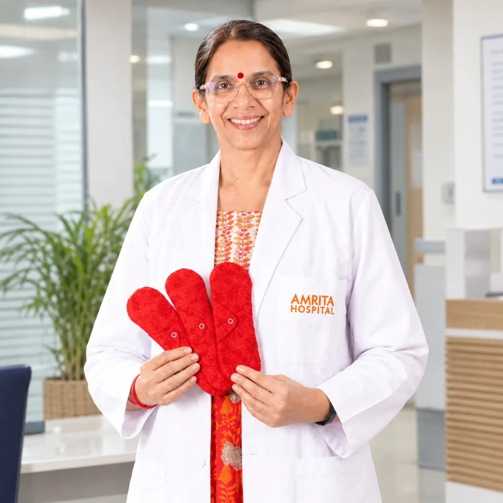 Doctor in a white lab coat holding red reusable cloth menstrual pads inside a modern hospital.