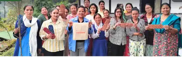 Community members holding reusable menstrual pads during a sustainable period care initiative